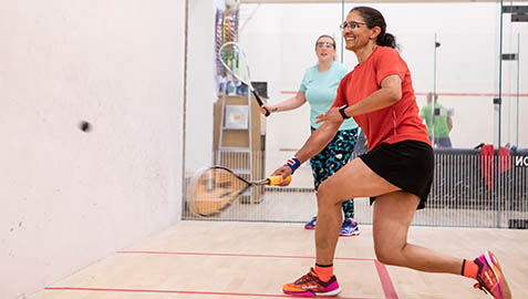 Two women playing squash on court